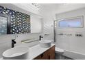 Modern bathroom features double sinks, sleek tilework, and a glass-enclosed shower at 105 Dudley St, Lakewood, CO 80226