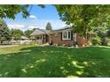 Beautiful brick home with a lush front lawn and garden, perfect for outdoor enjoyment at 105 Dudley St, Lakewood, CO 80226