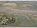 Overhead view of a countryside property with a comfortable house, several outbuildings, and vast open spaces at 7409 S County Road 157, Strasburg, CO 80136