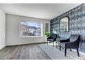 Stylish living room featuring a modern accent wall, large window, and sleek flooring at 7132 Eagle Rock Dr, Littleton, CO 80125