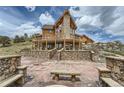 Striking log home with a stone facade, large deck, and stone benches, perfect for outdoor relaxation and entertaining at 401 Raptor Point Rd, Golden, CO 80403