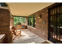 Relaxing porch with a swing and chairs, offering a comfortable outdoor space with brick walls at 2201 Cherry St, Denver, CO 80207