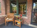 Inviting porch with a cozy seating area, including a chair and a table with decorative flowers and oranges at 2201 Cherry St, Denver, CO 80207