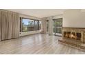 Bright living room featuring a cozy fireplace and scenic views from multiple windows and balcony access at 22453 Hillcrest Cir, Golden, CO 80401