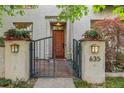 Elegant home entrance featuring a gated entryway with lovely planters leading to a solid wood front door at 635 N Williams St, Denver, CO 80218