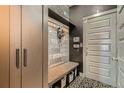Mud room with coat hooks, storage, a bench, and decorative floor tiles at 6792 Canosa St, Denver, CO 80221
