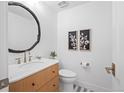 Elegant half bath with a wood vanity, marble countertop, and stylish mirror at 456 Cherry St, Denver, CO 80220