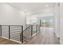 Open-concept hallway with modern railings and bright white walls at 8607 Yellowcress St, Littleton, CO 80125