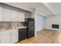 Efficient kitchen featuring white cabinets, and modern appliances adjoining a bright living space at 555 E 10Th Ave # 111, Denver, CO 80203