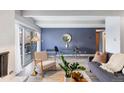 Open-concept living room with a fireplace, wood floors, and access to a balcony at 555 E 10Th Ave # 111, Denver, CO 80203