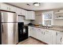 Well-lit kitchen featuring stainless steel appliances, granite countertops, and white cabinets at 377 Stuart St, Denver, CO 80219