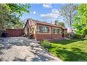 Quaint brick home featuring an American flag, garden, outdoor seating, and a private entrance at 9301 Ciancio St, Thornton, CO 80229
