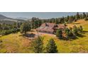 House with a tennis court and mountain backdrop at 22196 Boar Head Rd, Indian Hills, CO 80454