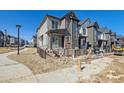 Modern two-story townhome featuring varied siding and a partially fenced front yard; landscaping is in progress at 458 Millwall Cir, Castle Pines, CO 80108