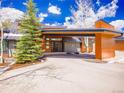 Beautiful home exterior with architectural wood elements, mountain view, and covered parking at 34089 Woodland Dr, Evergreen, CO 80439