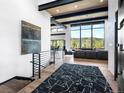 Bright open-concept living room with hardwood floors, mountain view, and modern staircase at 34089 Woodland Dr, Evergreen, CO 80439