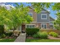 Charming townhome featuring stone accents, well-maintained landscaping, and a welcoming front entrance at 14300 Waterside Ln # E3, Broomfield, CO 80023