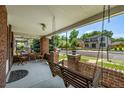 Inviting porch with swing, table, chairs and brick columns provides a great space for outdoor relaxation and street view at 4654 Bryant St, Denver, CO 80211
