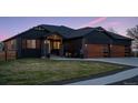Charming home with a well-manicured lawn, modern wooden garage doors, and a cozy front patio area at 740 W County Road 10E, Berthoud, CO 80513