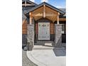 Close-up of the home's welcoming front door with stone pillars and natural wood accents, exuding warmth and charm at 740 W County Road 10E, Berthoud, CO 80513
