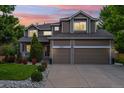 Charming two-story home featuring a covered porch, landscaped front yard, and attached two-car garage at 18027 E Ida Dr, Centennial, CO 80015