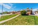 Beautifully landscaped front yard of a brick home with green lawn and clear walkway at 7651 Shoshone St, Denver, CO 80221