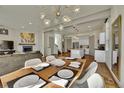 Open concept dining and living room area boasts hardwood floors, modern lighting, and fireplace at 4035 Fenton Ct, Wheat Ridge, CO 80212