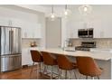 Modern kitchen with stainless steel appliances, a center island with seating, and white cabinets at 4035 Fenton Ct, Wheat Ridge, CO 80212