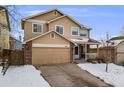 Charming two-story home with a two-car garage and a cozy front porch, surrounded by a snow-covered yard at 4821 N Silverlace Dr, Castle Rock, CO 80109