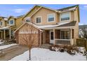 Charming two-story home with a two-car garage and a cozy front porch, surrounded by a snow-covered yard at 4821 N Silverlace Dr, Castle Rock, CO 80109