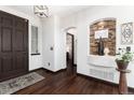 Inviting foyer featuring dark wood floors, a decorative stone alcove, and a stylish front door at 3791 Charterwood Cir, Highlands Ranch, CO 80126