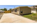 Well-maintained single-story home featuring a concrete driveway, a wooden fence, and a tidy, compact lawn at 311 Harrison Ave, Fort Lupton, CO 80621