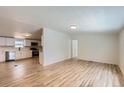 Bright open-concept living space with new floors, seamlessly flowing into the modern kitchen at 311 Harrison Ave, Fort Lupton, CO 80621