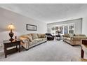 Spacious living room with large windows, plush sofas, and neutral decor creating a warm and inviting atmosphere at 12423 W 68Th Ave, Arvada, CO 80004