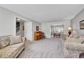Open-concept living room with a piano, doorway to the staircase, and dining area view at 12423 W 68Th Ave, Arvada, CO 80004