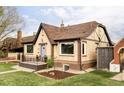 Charming brick home with a gabled roof, manicured lawn and blue entry door at 4828 W 32Nd Ave, Denver, CO 80212