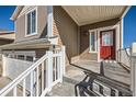 Front porch with a red door and storm door and a view of the two car garage at 5534 Killarney St, Denver, CO 80249