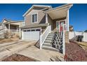 This beautiful home features a two car garage and landscaped yard with a red front door at 5534 Killarney St, Denver, CO 80249