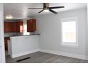 Inviting living room with new gray flooring, a ceiling fan, a breakfast bar, and access to the kitchen at 4460 Columbine St, Denver, CO 80216