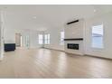 Bright living room with modern fireplace, light wood floors, and open layout at 920 Promenade Dr, Superior, CO 80027