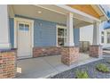 Inviting front porch with brick pillars and a charming entrance to the home at 920 Promenade Dr, Superior, CO 80027