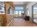 Bright sun room featuring brick floors, large windows, a telescope, and scenic views at 11039 Roxborough Dr, Littleton, CO 80125