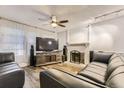 Inviting living room with modern decor, a fireplace, and a ceiling fan at 3827 S Fraser St, Aurora, CO 80014