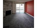 Carpeted living room features a stone fireplace and sliding glass door to the exterior at 7000 W 20Th Ave # 106, Lakewood, CO 80214