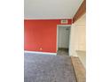 Cozy carpeted living room with a bright red accent wall and neutral color scheme at 7000 W 20Th Ave # 106, Lakewood, CO 80214