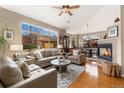 Bright living room features hardwood floors, large windows, and a cozy fireplace at 8617 Gold Peak Dr # G, Highlands Ranch, CO 80130