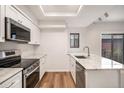 Modern kitchen features stainless steel appliances, granite countertops, and wood floors at 2685 S Dayton Way # 234, Denver, CO 80231