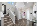 Bright foyer with hardwood floors, staircase, and high ceilings creates an inviting entrance at 9342 Bear River St, Littleton, CO 80125
