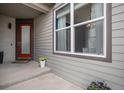 Inviting front porch with a vibrant red door, large window, and decorative flower pots at 9342 Bear River St, Littleton, CO 80125