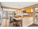 Bright kitchen boasts light wood cabinets, stainless appliances, and a stylish breakfast bar island at 3270 S Washington St, Englewood, CO 80113